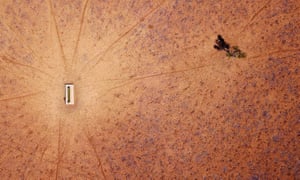 A lone tree stands near a water trough in a drought-effected paddock on Jimmie and May McKeown’s property located on the outskirts of town of Walgett, in New South Wales, Australia,
