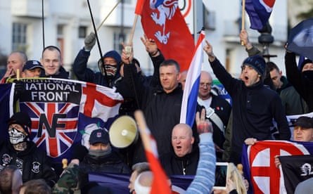 A group of protesters hold up flags in Dover