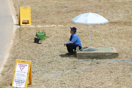 A man sits in the shade to avoid the heat in Seoul, South Korea.