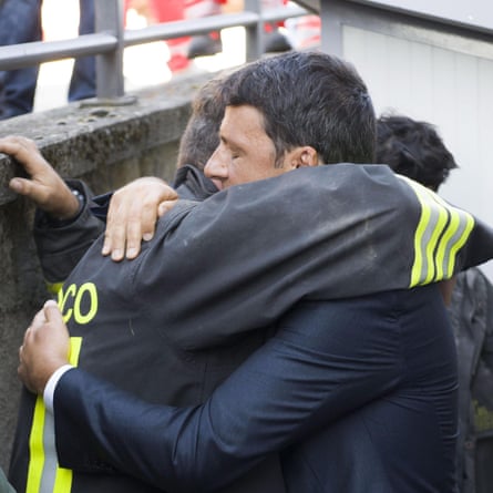 Renzi hugs a rescuer in Amatrice.
