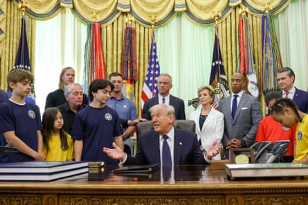 Donald Trump in the Oval Office with a group of people.