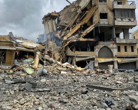 A collapsed building surrounded by piles of rubble