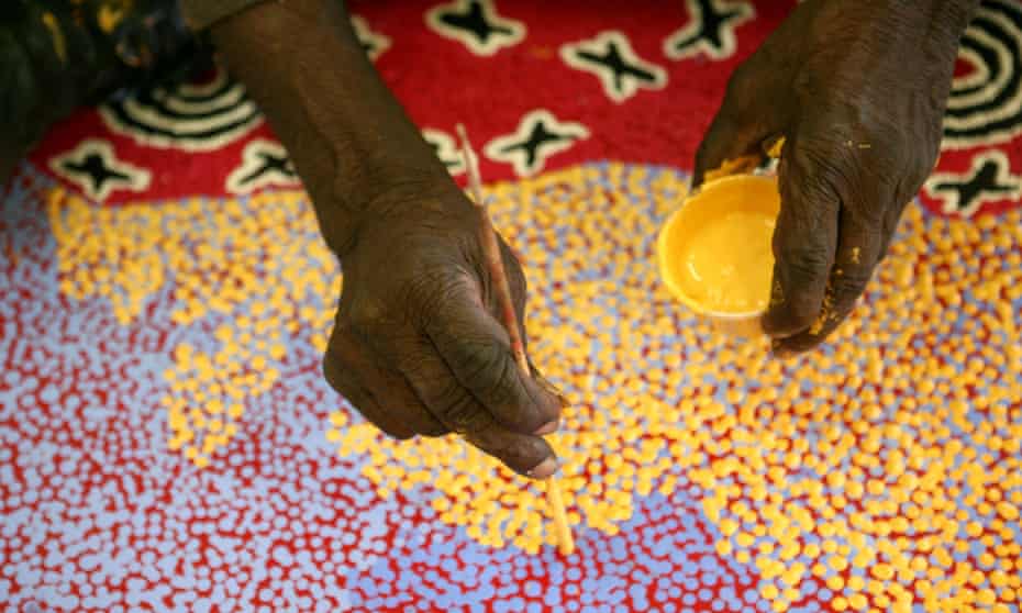 Aboriginal artist Paddy Stewart works on a dot painting at the Ngurratjuta Iltja Ntjarra Many Hands Art Center in Alice Springs in the Northern Territory