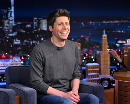 person wearing grey sweater sits on navy chair