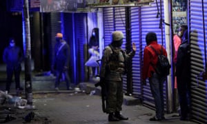 A member of the South African military talks to a man during a patrol as a nighttime curfew is reimposed amid a nationwide coronavirus lockdown, in Johannesburg, South Africa, 13 July 2020.