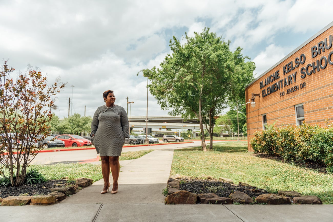 Black woman stands for a portrait next to school