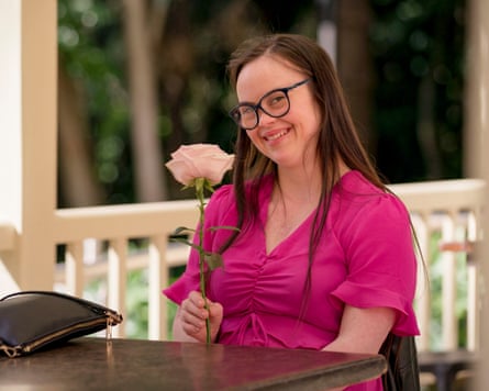 Olivia holds a long-stemmed rose, smiling
