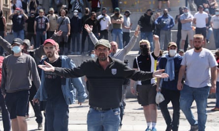 Activists from far-right linked groups chant as they face police officers in central London on Saturday.