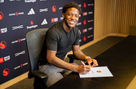 Kobbie Mainoo poses to mark the signing of his new Manchester United contract