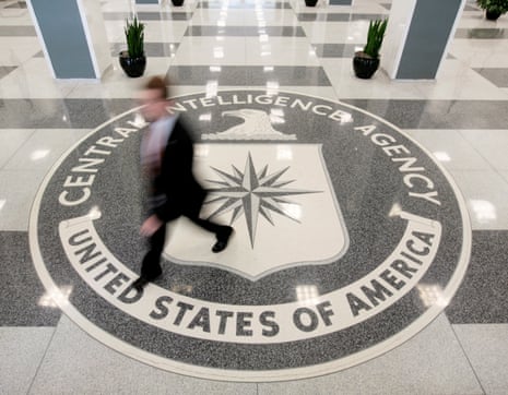 A man in a suit is a blur as he walks across the white and gray marble CIA seal in the lobby of the CIA headquarters.