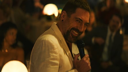 A grinning man in a white jacket