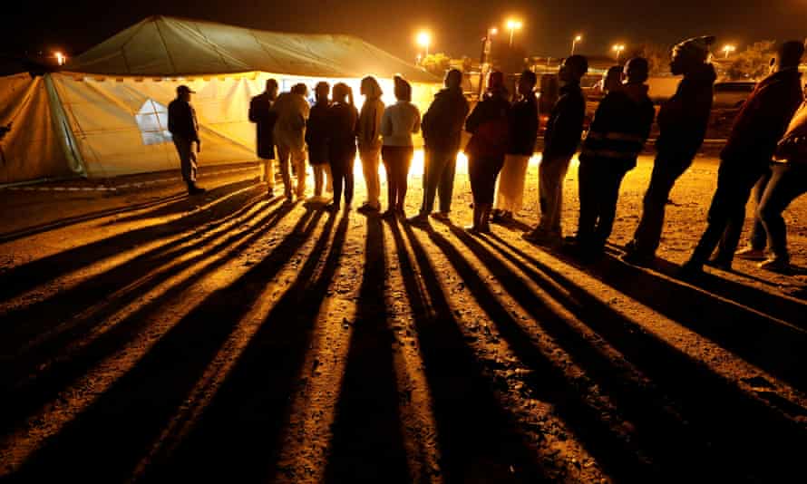 Voters queue to cast their ballots before polls closed outside a polling station in Alexandra township in Johannesburg on Wednesday