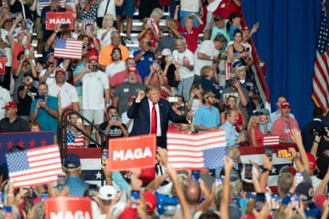 President Trump dances with raised fists before a cheering crowd holding MAGA signs and flags