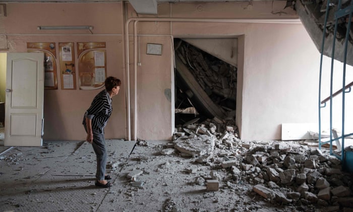 A teacher examines destructions in a school destroyed as a result of a shelling in Bakhmut, Donetsk region.