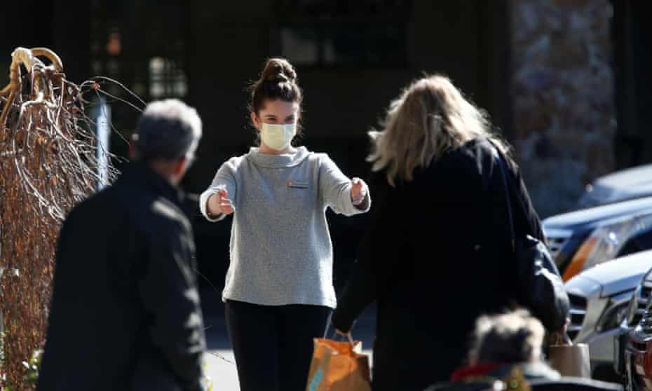 A staff member wearing a mask receives bags of supplies at the Life Care Center of Kirkland.