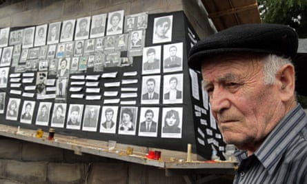 An Ossetian man stands in front of pictures of locals killed during the 2008 South Ossetia conflict.