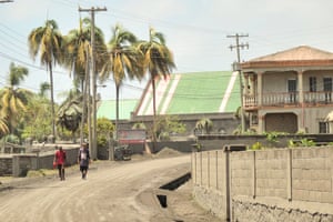 Volcanic ash covers St Vincent – in pictures 3 Men walk down a street after eruptions from La Soufrière volcano covered the area with a thick layer of ash in Georgetown.