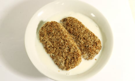 Two pieces of Weetabix in a bowl of milk