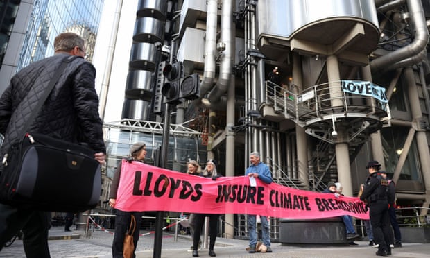people hold a banner saying Lloyd's insure climate breakdown