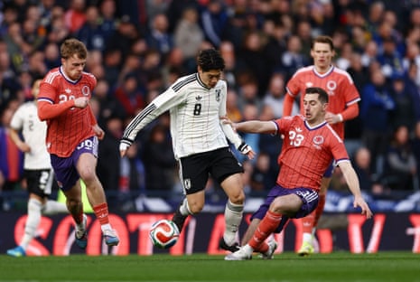 Japan's Yuito Suzuki is challenged by Kenny McLean.