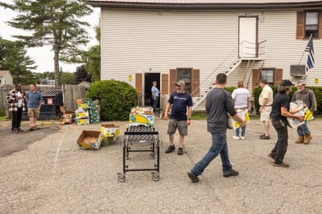 Volunteers and patrons load up boxes and bags of food.