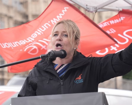 Sharon Graham making a speech with Unite flags in the background