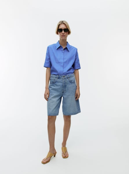 Model wearing denim Bermuda shorts and blue stripe shirt