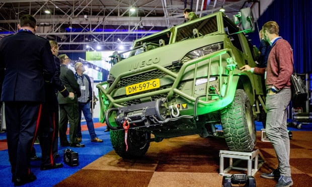 Defense industry professionals look at a military vehicle on display at an arms fair in the Netherlands.