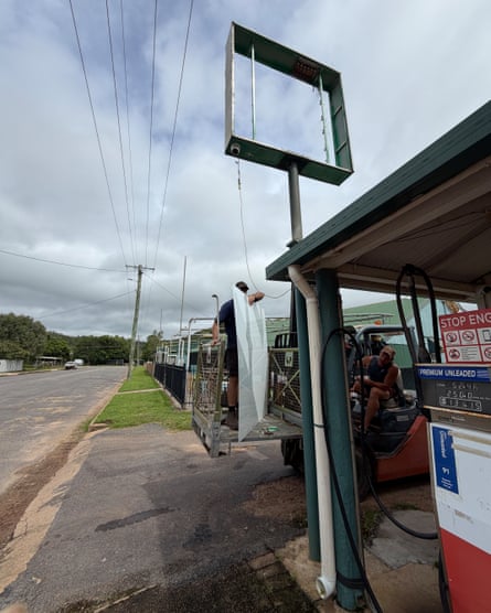 Person taking down sign from outside service station