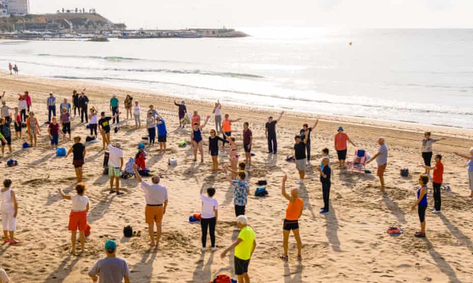 People doing exercises on a beach in Benidorm, Spain.