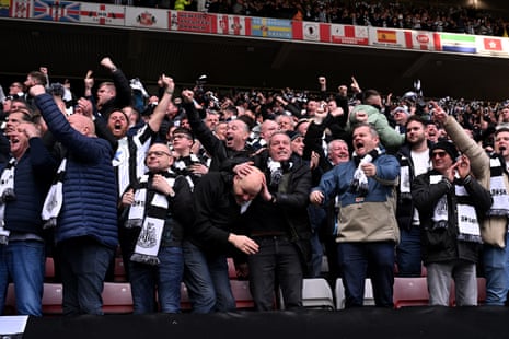 Fans of Newcastle United celebrate after Daniel Ballard’s own goal gives their team the lead.