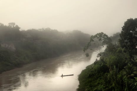 Sunrise on the Amônia River. Boat carrying one person seen from a distance