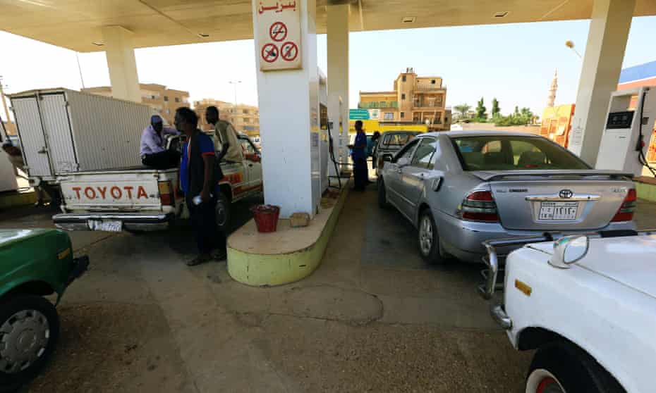 People gather to get fuel at a petrol station in Khartoum, Sudan