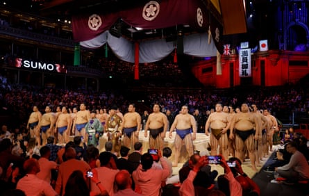 Sumo wrestlers stand in a ring facing towards the crowds at the Royal Albert Hall.