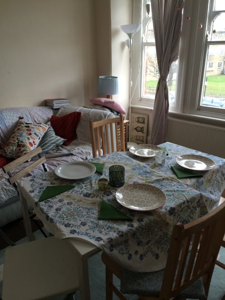A dinner table dressed with a tablecloth, napkins and four plates