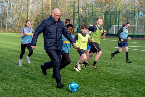 Scottish first minister John Swinney playing football with some children