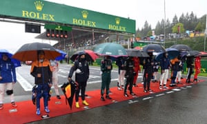 Drivers with umbrellas at the start line