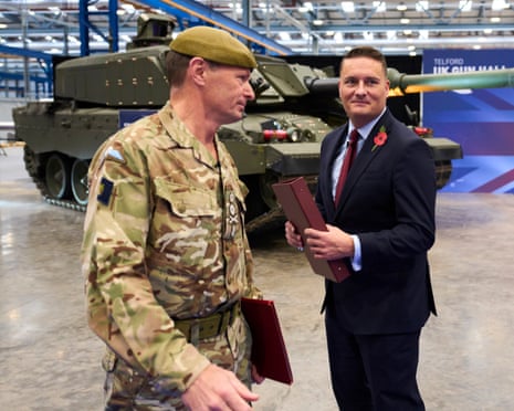 Wes Streeting and General Sir Roland Walker standing in front of a tank in a hall