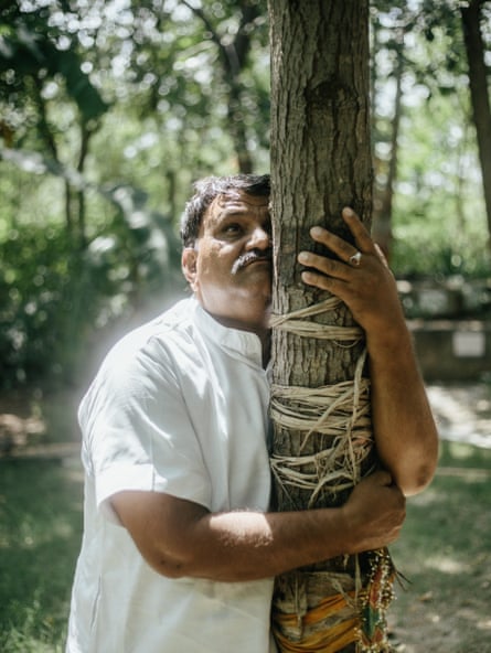 Shyam Sunder Paliwal hugs the burflower tree planted in remembrance of his daughter.