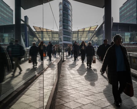 Commuters make their way to work in Manchester city centre.