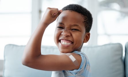 Portrait of a little boy with a plaster on his arm after an injection, looking pleased