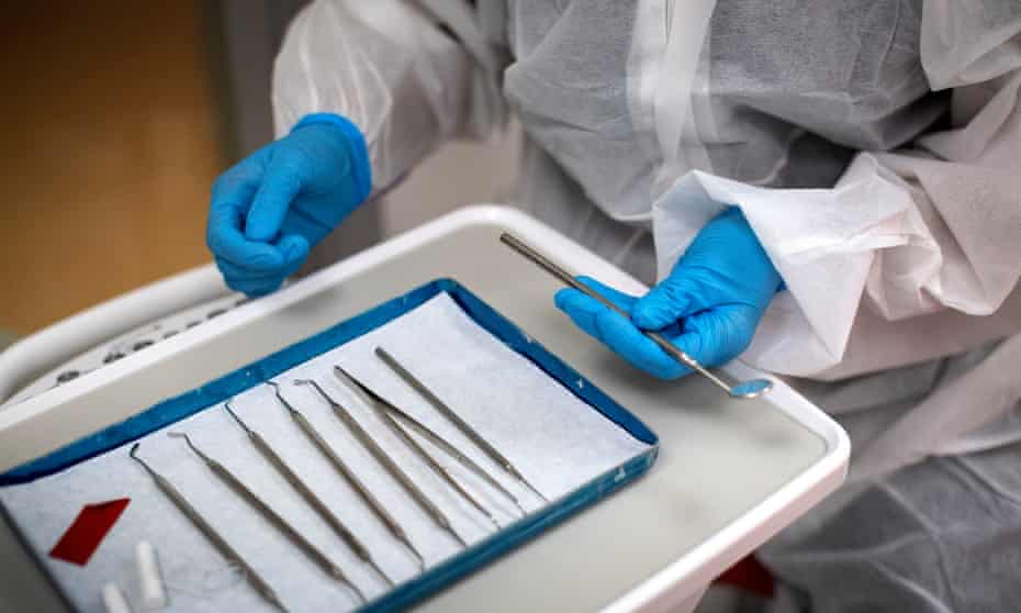 A dentist prepares to treat a patient
