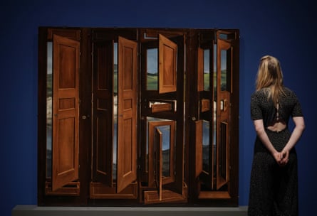 A gallery staff member stands next to Surrealist Wardrobe, by Marcel Jean, 1941 – part of Surrealism Beyond Borders