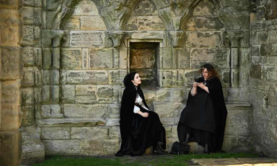 Two women dressed as vampires sitting down under arches in the Abbey