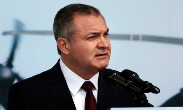 man in suit speaks into microphone