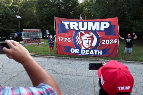 Supporters of Donald Trump hold a banner at the entrance of the Fulton County Jail, as he is expected to turn himself in to be processed after his Georgia indictment.