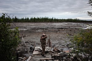 Leonid Nalyotov stands along what used to be a lake behind his home along the Kolyma river in Yakutia, Siberia. Land once separated the lake from a nearby river, but a channel formed after the land collapsed from the thawing permafrost, draining the lake.