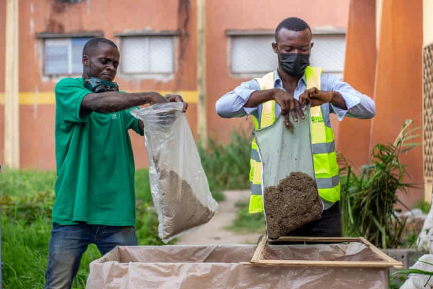 Kouebatouka and another in his team put the processed water hyacinth into bags.