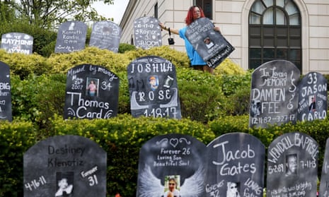 Jayde Newton helps to set up cardboard gravestones with the names of victims of opioid abuse for a demonstration on 9 August in White Plains, New York.