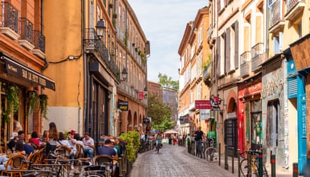 Pedestrianised street with pavement cafe, colourful buildings and parked bicycles